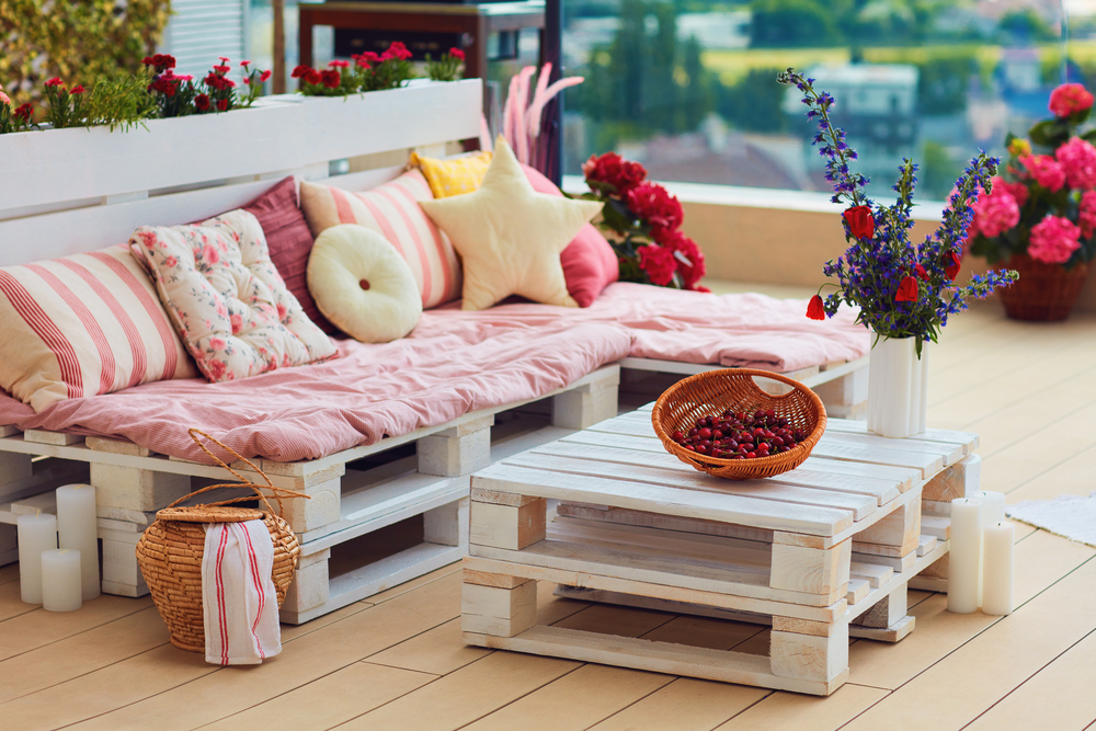 cute, cozy pallet furniture with colorful pillows at summer patio, lounge outdoor space